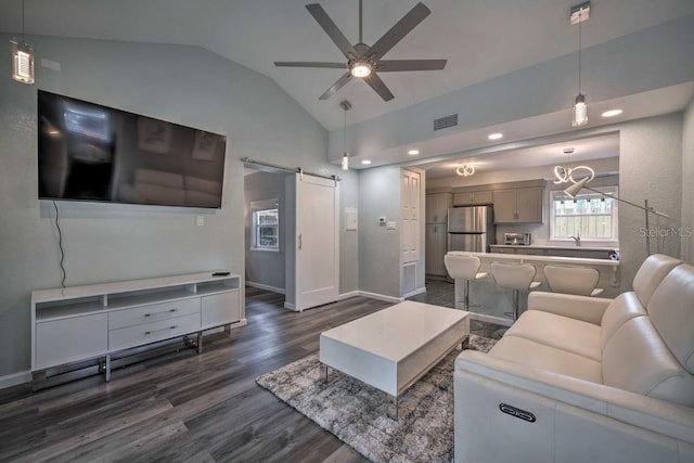 living area featuring a barn door, visible vents, a ceiling fan, lofted ceiling, and dark wood-type flooring