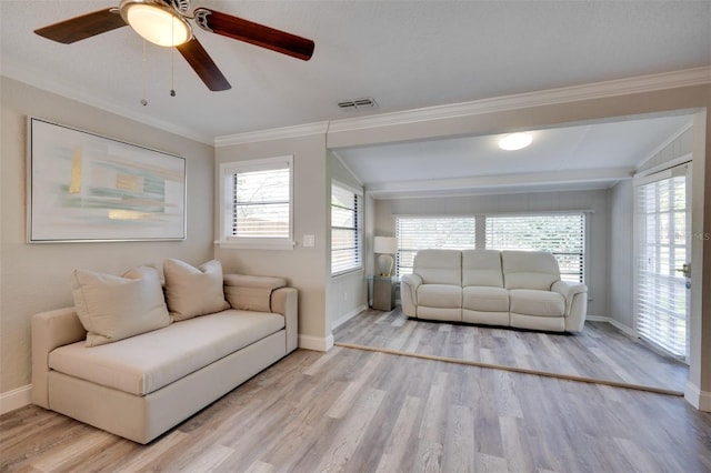 living room featuring ornamental molding, a wealth of natural light, wood finished floors, and visible vents