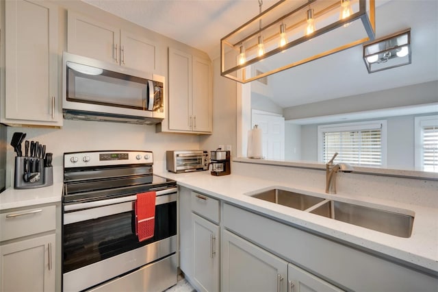 kitchen with lofted ceiling, stainless steel appliances, a sink, and a toaster