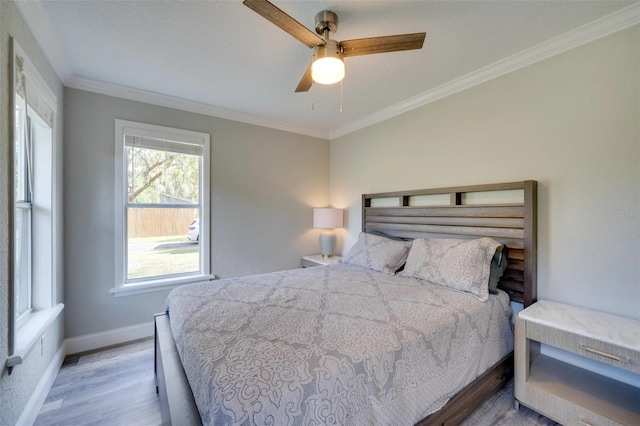 bedroom featuring ceiling fan, ornamental molding, wood finished floors, and baseboards