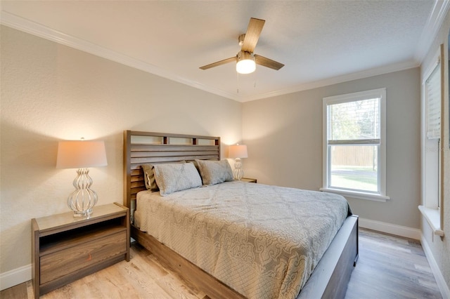 bedroom featuring baseboards, light wood finished floors, a ceiling fan, and crown molding