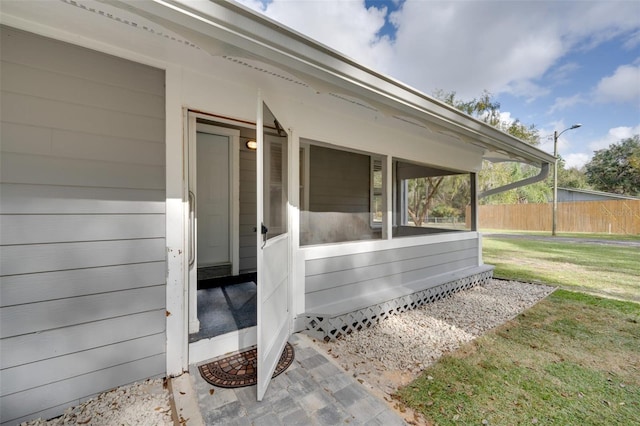 entrance to property with a yard and fence