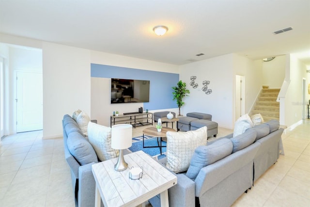 living room with light tile patterned floors, stairway, and visible vents