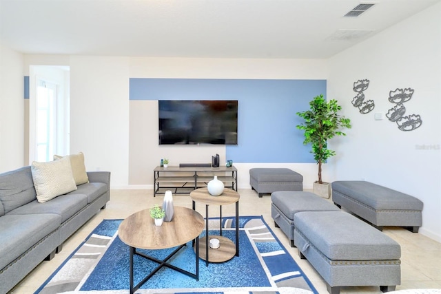 living area featuring baseboards and visible vents