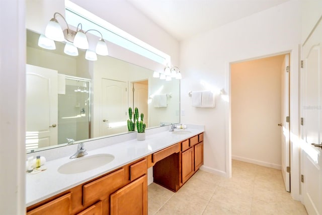 full bathroom with double vanity, a stall shower, baseboards, and a sink