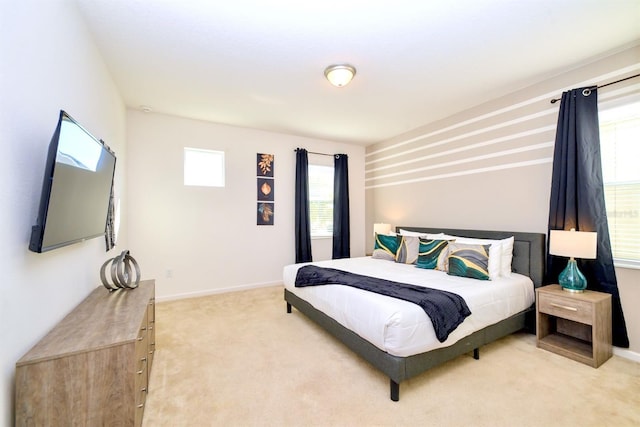 bedroom with light colored carpet and baseboards