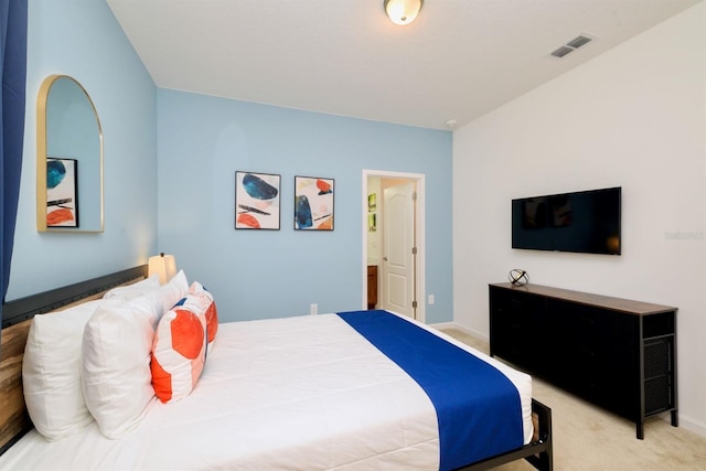 carpeted bedroom featuring connected bathroom, visible vents, and baseboards