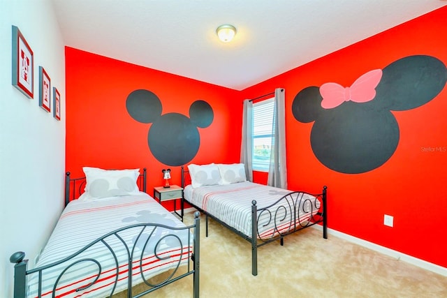 carpeted bedroom with an accent wall and baseboards