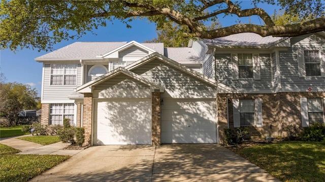 view of front facade featuring a garage, concrete driveway, brick siding, and a front yard