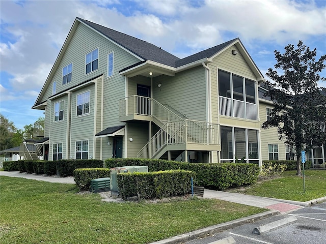 view of property with uncovered parking and stairway