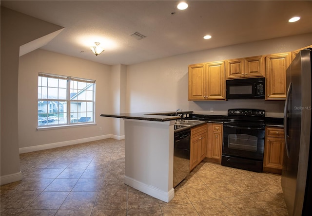 kitchen with dark countertops, visible vents, a sink, a peninsula, and black appliances