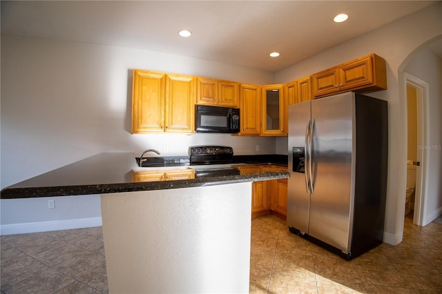 kitchen with black microwave, a peninsula, range with electric stovetop, stainless steel fridge with ice dispenser, and glass insert cabinets