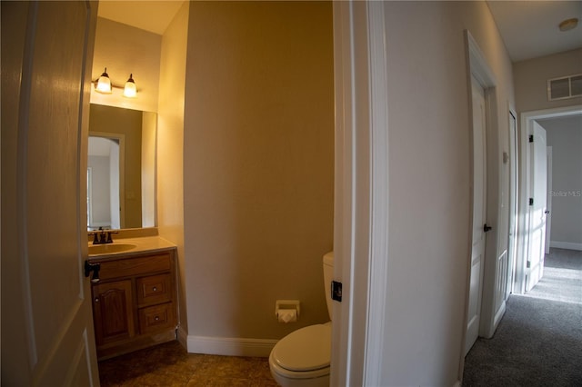 bathroom with toilet, baseboards, visible vents, and vanity