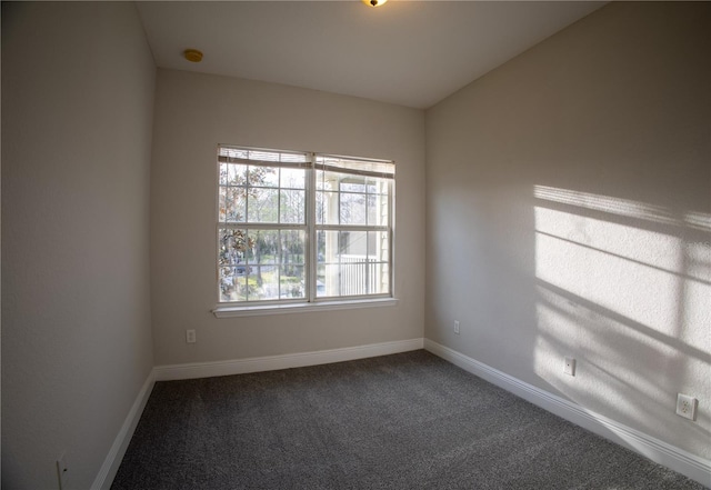 carpeted spare room with baseboards