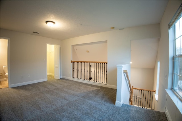 carpeted empty room with visible vents and baseboards