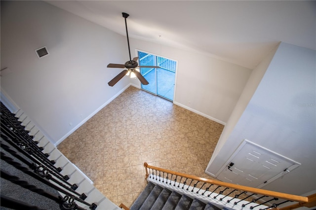 staircase featuring vaulted ceiling, ceiling fan, visible vents, and baseboards