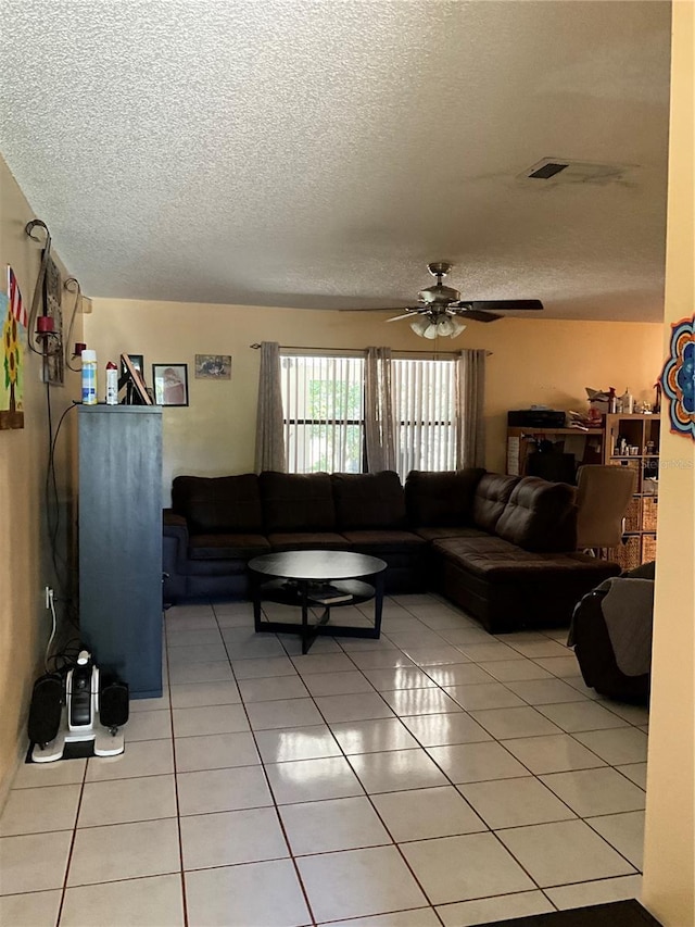 living area featuring a ceiling fan, visible vents, a textured ceiling, and light tile patterned floors