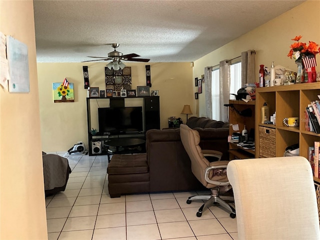 living area with light tile patterned flooring, ceiling fan, and a textured ceiling