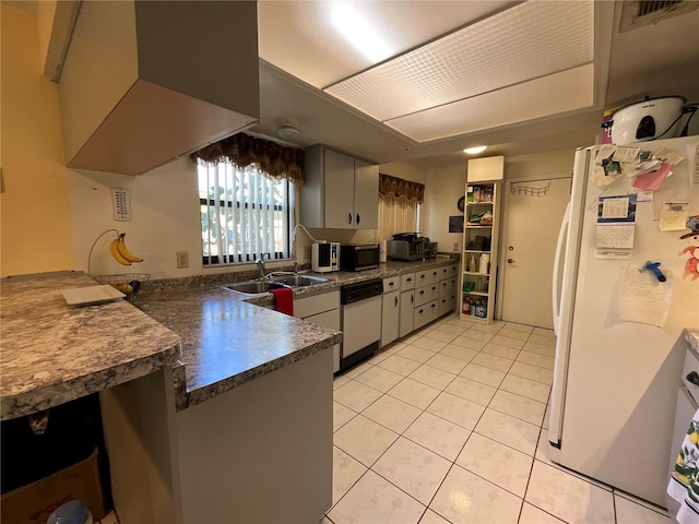 kitchen featuring white appliances, visible vents, dark countertops, a peninsula, and light tile patterned flooring