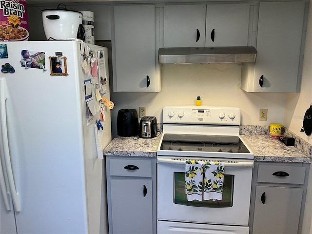 kitchen featuring gray cabinets, white appliances, light countertops, and under cabinet range hood