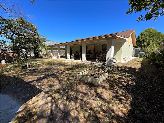 rear view of property with fence, concrete block siding, and a patio