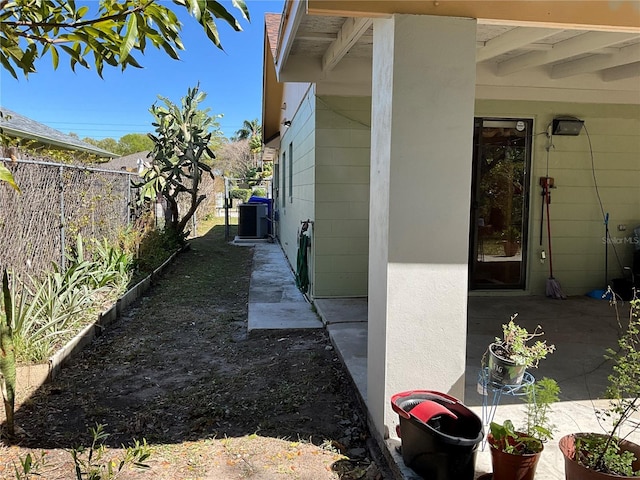 view of side of home featuring central AC, a patio area, and a fenced backyard