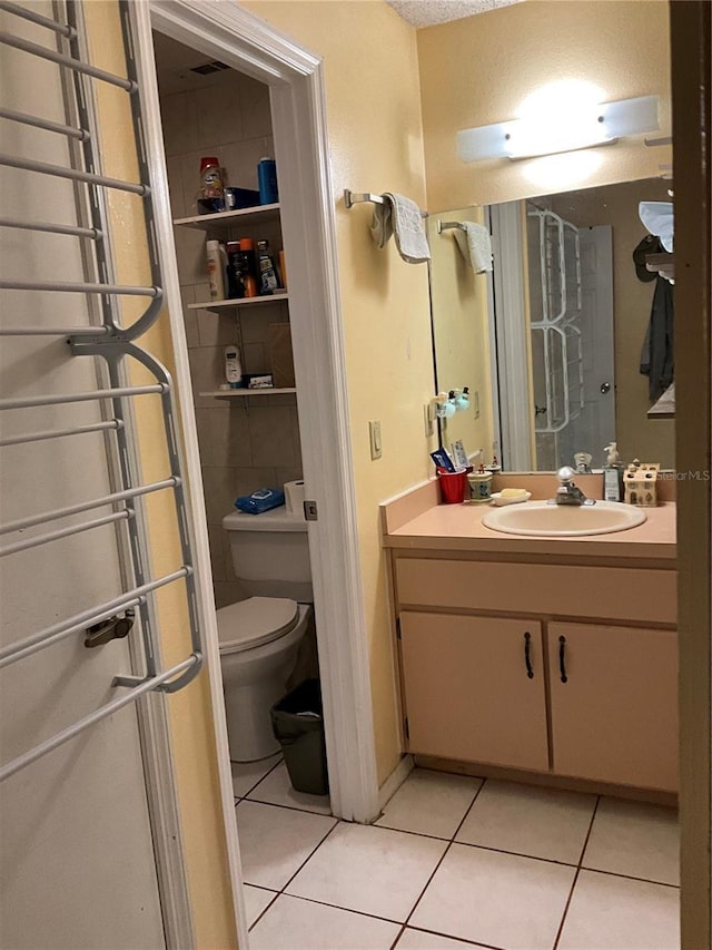 bathroom featuring toilet, tile patterned flooring, a textured ceiling, and vanity