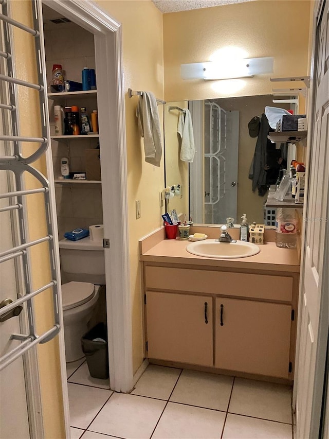 bathroom featuring toilet, vanity, and tile patterned floors