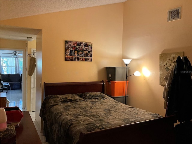 bedroom with tile patterned flooring, visible vents, and vaulted ceiling