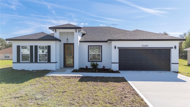 view of front of property with an attached garage, driveway, roof with shingles, stucco siding, and a front yard