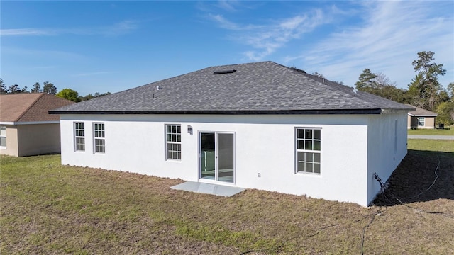 back of property featuring roof with shingles and a lawn