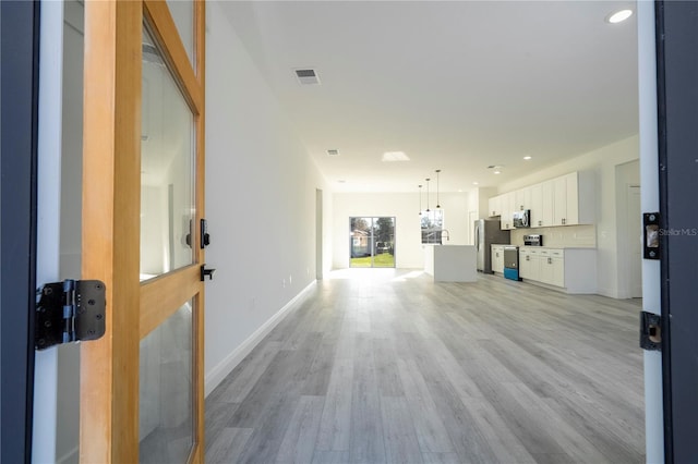 living area featuring light wood-type flooring, baseboards, visible vents, and recessed lighting