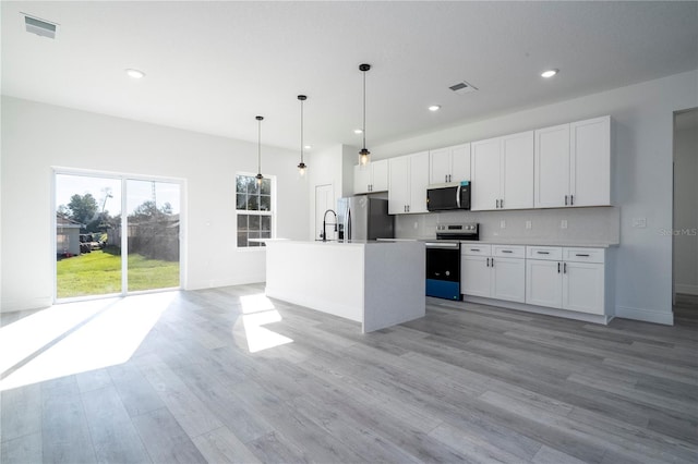 kitchen featuring appliances with stainless steel finishes, visible vents, backsplash, and white cabinetry