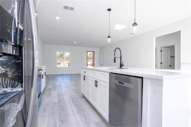 kitchen with stainless steel appliances, a sink, visible vents, white cabinets, and light wood finished floors