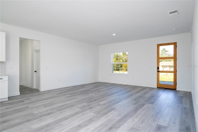 unfurnished living room with light wood finished floors, recessed lighting, visible vents, and baseboards