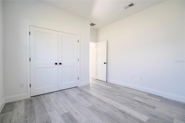 unfurnished bedroom with light wood-style flooring, visible vents, and baseboards