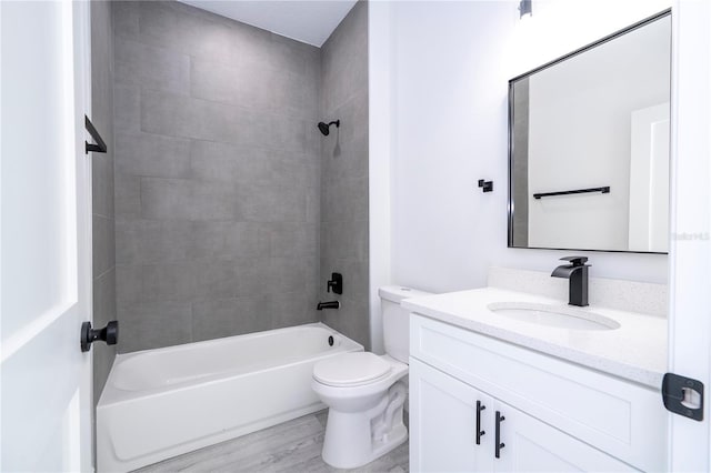 full bath featuring wood finished floors, tub / shower combination, vanity, and toilet