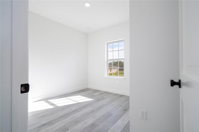 spare room featuring baseboards and wood finished floors