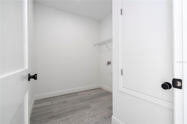 laundry room featuring laundry area, light wood-type flooring, and baseboards