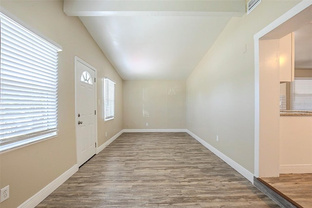 foyer entrance with visible vents, baseboards, wood finished floors, and vaulted ceiling with beams