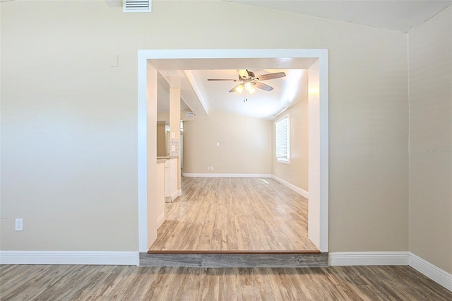 interior space with visible vents, baseboards, wood finished floors, and vaulted ceiling