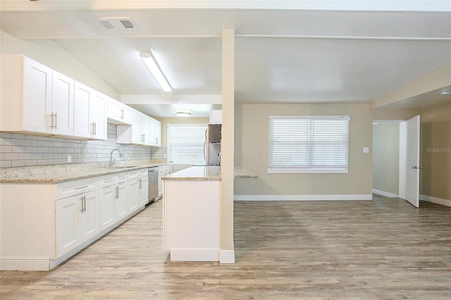 kitchen featuring backsplash, stainless steel dishwasher, white cabinetry, fridge, and light wood finished floors