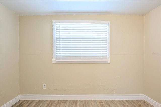 empty room featuring wood finished floors and baseboards