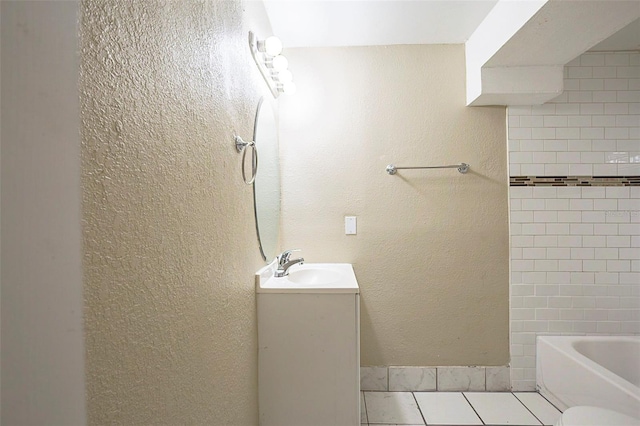 bathroom with vanity, tile patterned floors, a textured wall, and shower / bath combination