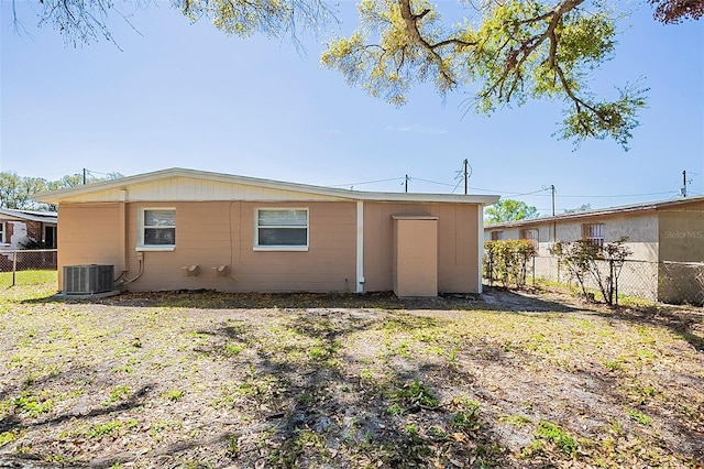 rear view of house featuring cooling unit and fence