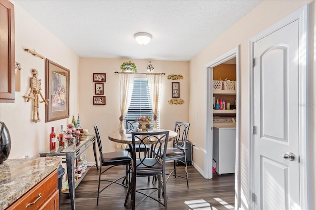 dining area featuring a textured ceiling, dark wood-style flooring, washer / dryer, and baseboards