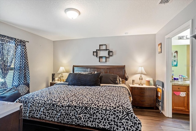 bedroom featuring a textured ceiling and wood finished floors