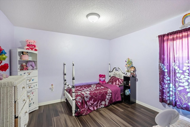 bedroom with dark wood-style floors, baseboards, and a textured ceiling