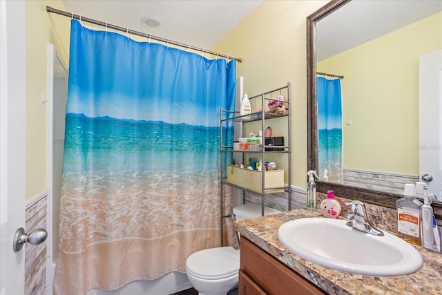 bathroom featuring toilet, a textured ceiling, and vanity