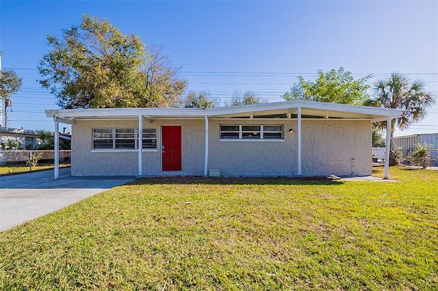 view of front of house with stucco siding, a front lawn, and fence